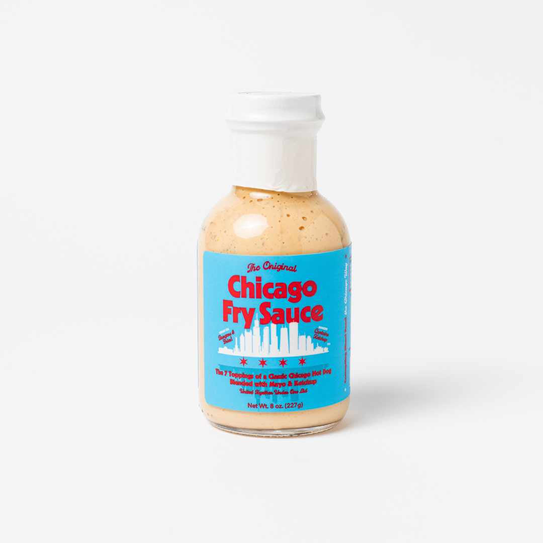 A clear glass bottle with a white cap holds Burger & French Fry Dipping Sauce: Chicago Fry Sauce. The label features "The Original Chicago Fry Sauce" in red and blue on light blue, with illustrations of fries and hot dogs.