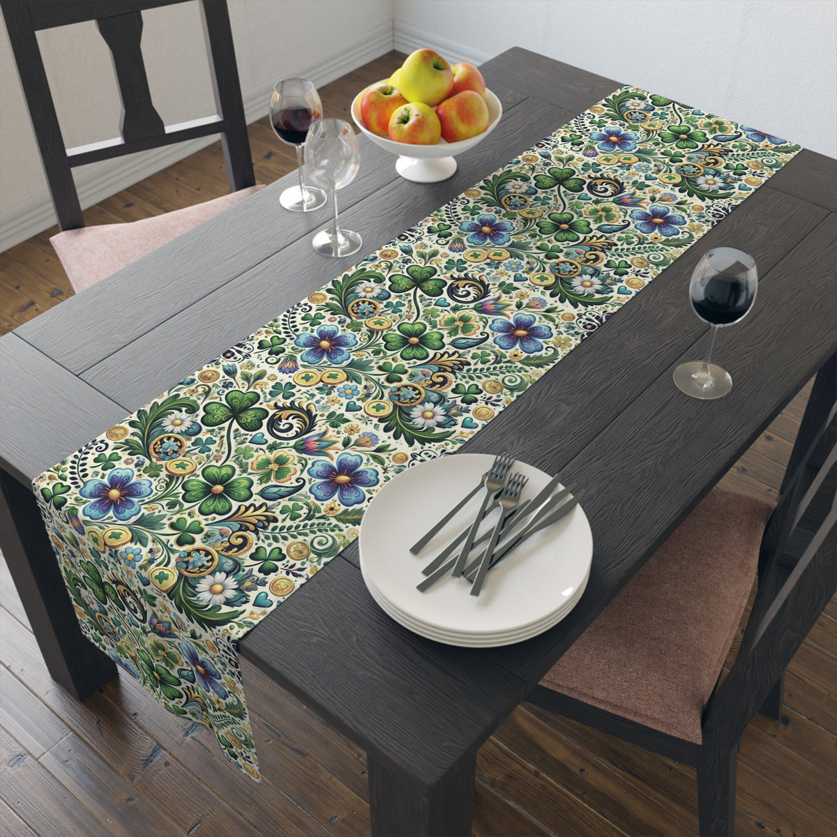 A dark wooden dining table set for two features wine glasses, utensils, a fruit bowl, and a Floral Table Runner with green, blue, and yellow floral patterns that adds vibrant charm to the elegant decor.