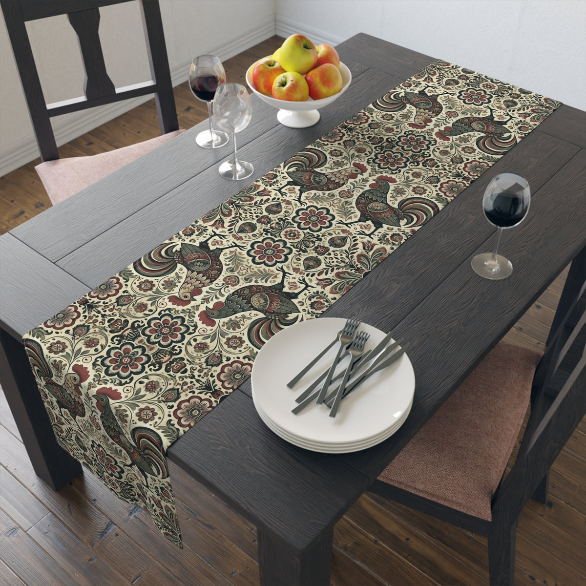 A dark wood dining table features the Retro Themed Polish Wycinanki Rooster Floral Table Runner. Two place settings with plates, cutlery, wine glasses, and a fruit bowl of apples, pears, and bananas complete this elegant home décor scene.