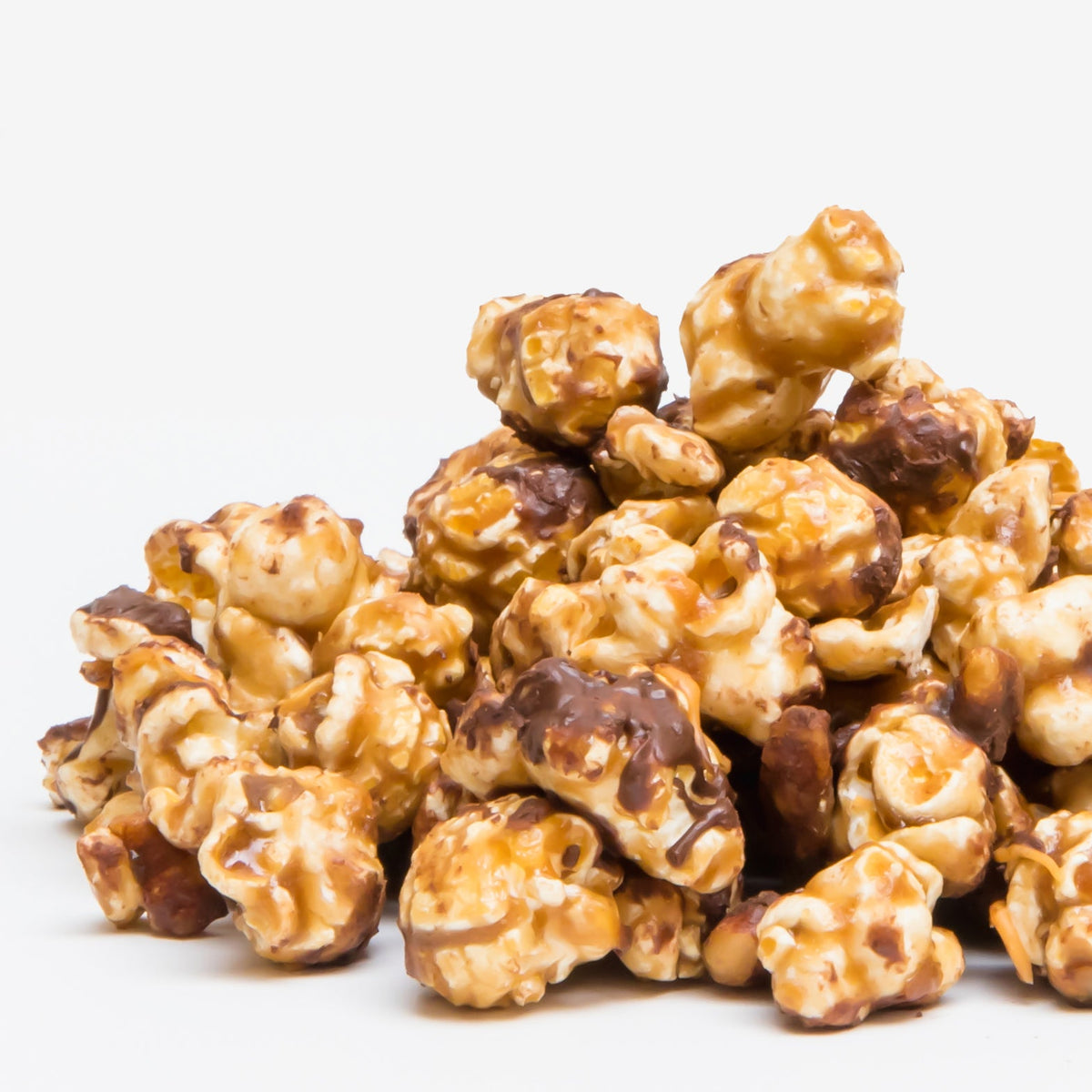 Turtle Popcorn—caramel popcorn pieces, some drizzled with rich dark chocolate for a Turtle Popcorn twist—are shown against a plain white background.