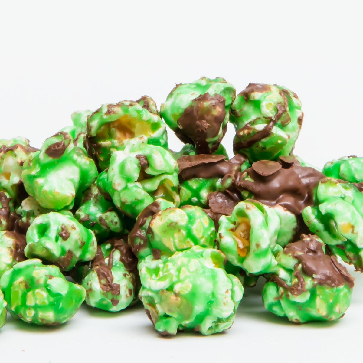 Chocolate Mint Popcorn features peppermint popcorn coated in green candy and topped with a dark chocolate drizzle, presented against a white background.