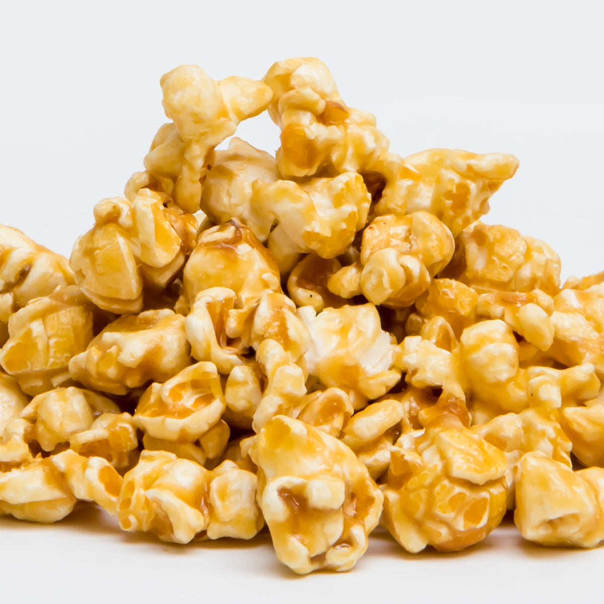 A pile of Caramel Popcorn from Colorado Popcorn Company sits on a plain white background, highlighting this classic treat.