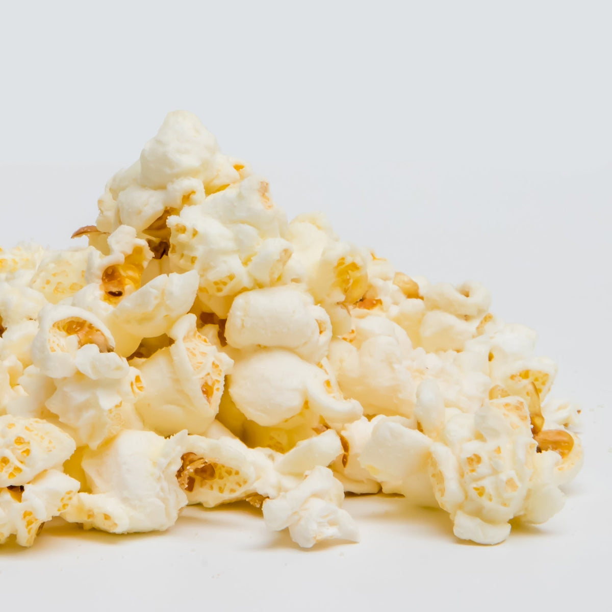 White Cheddar Popcorn is shown in a pile against a plain white background.
