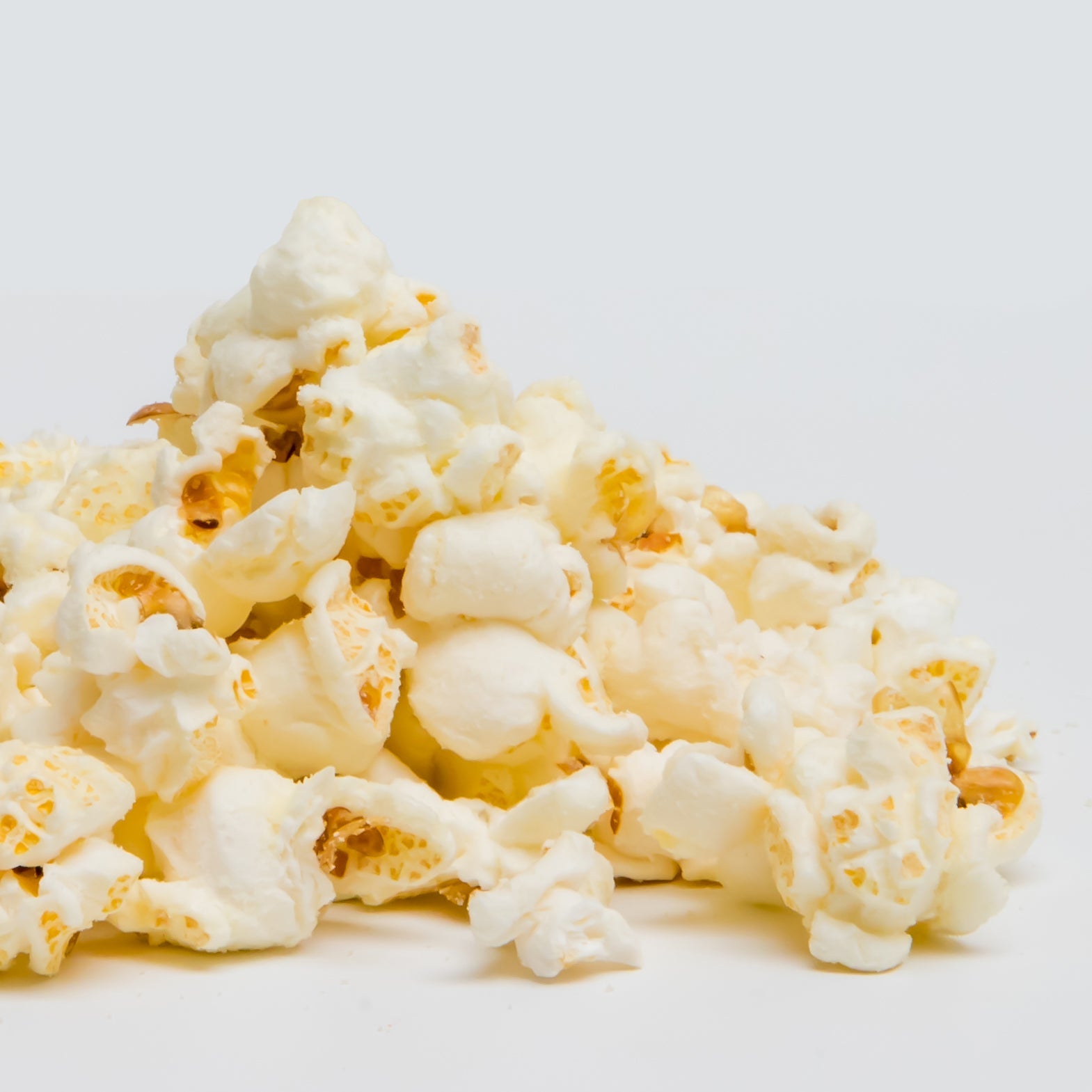White Cheddar Popcorn is shown in a pile against a plain white background.