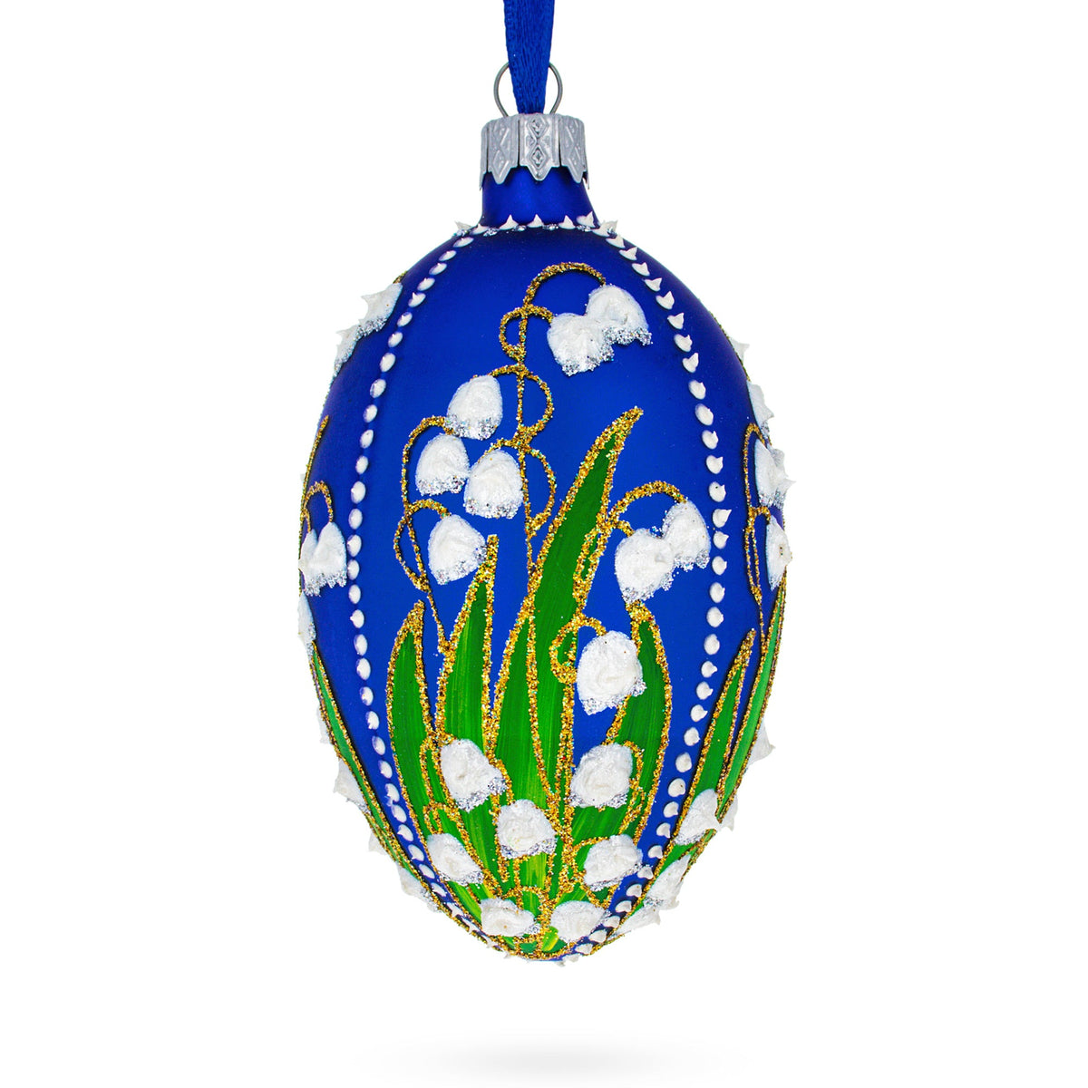 The 1898 Lilies of the Valley Royal in Blue Egg Glass Ornament (4&quot;) is handcrafted in Ukraine, featuring painted green leaves, white flower designs, gold accents, and a blue ribbon—an elegant addition to any Christmas tree.