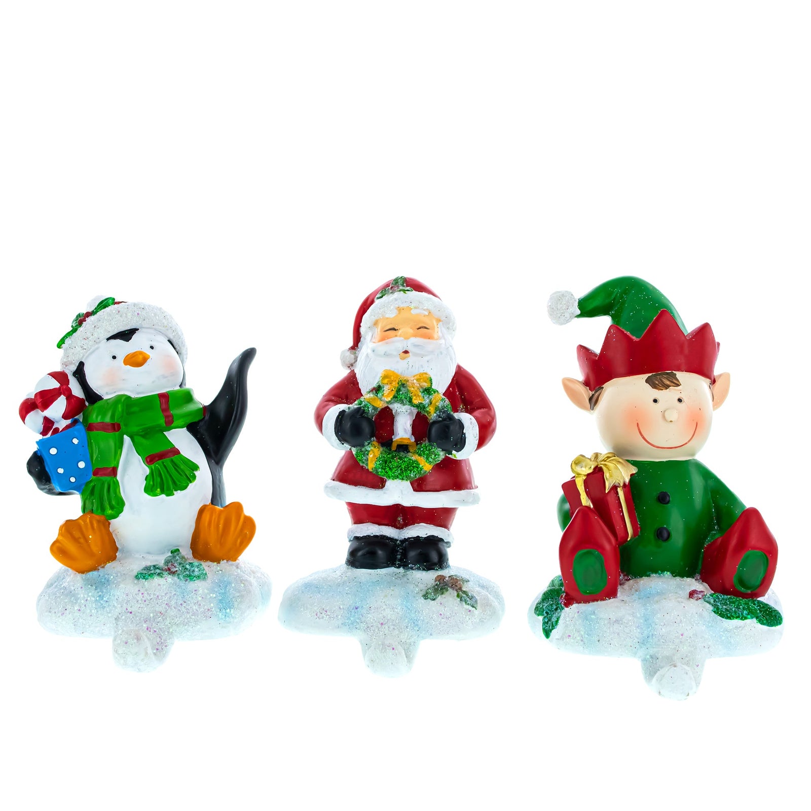 Set of 3 Christmas Stocking Holders Hangers—Santa, Penguin, and Elf—make charming holiday mantel decorations, each hand-painted and featuring festive details on snowy bases to add cheer to your home's seasonal décor.