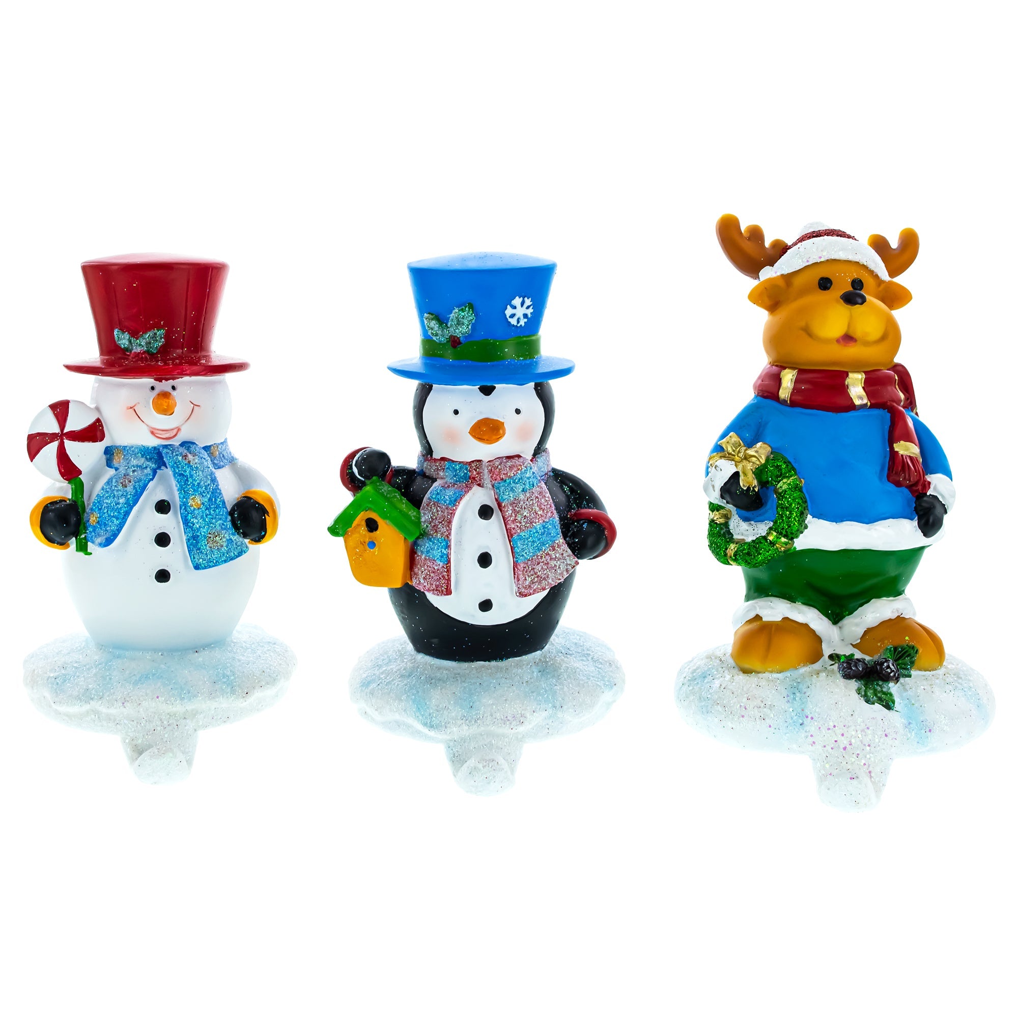 This set of 3 Holiday Stocking Holders features a snowman, penguin, and reindeer on snowy bases, each with a festive hat and scarf—perfect Christmas mantel decor for hanging stockings.